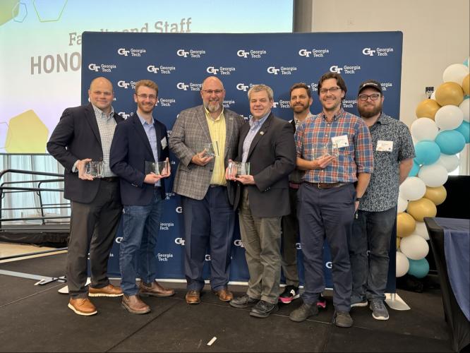 Photo of GA-AIM team holding the instiute awards